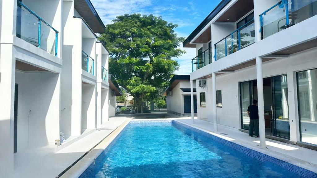 a man standing in front of a house with a swimming pool at Diver's home resort in Panglao Island
