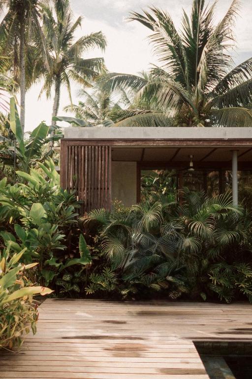a house with palm trees and a wooden porch at Kamaya - Private Villa with Pool in General Luna