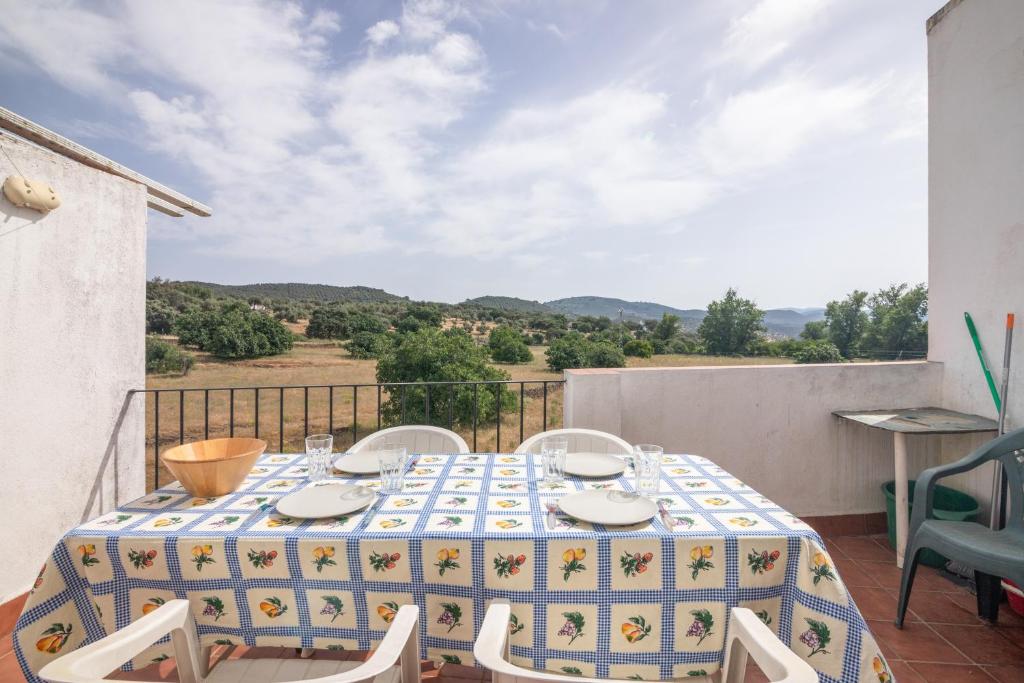 a table and chairs on a balcony with a view at El Corralon de Severo in Hinojales