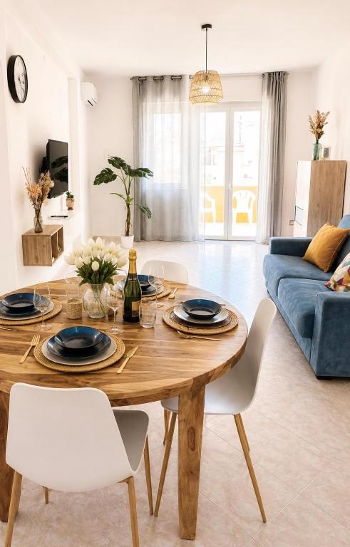a living room with a wooden table and a blue couch at Alguer Zizì in Alghero