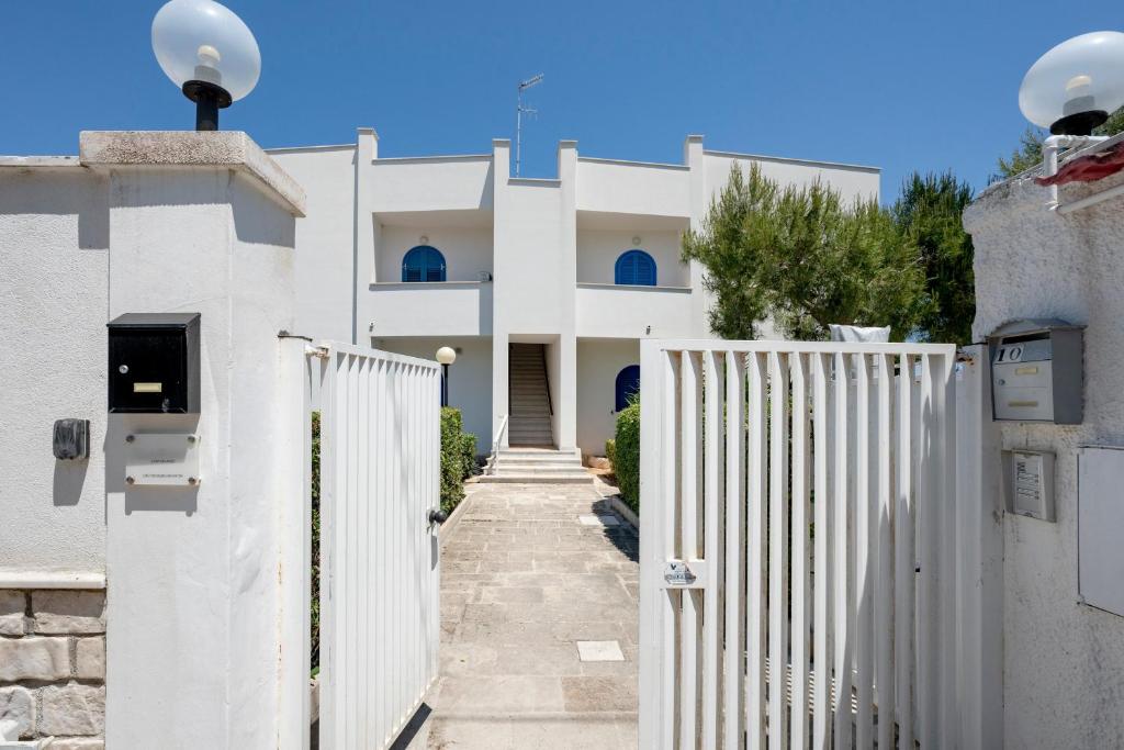 a white fence in front of a white house at Casa del Riccio fronte mare in Mola di Bari