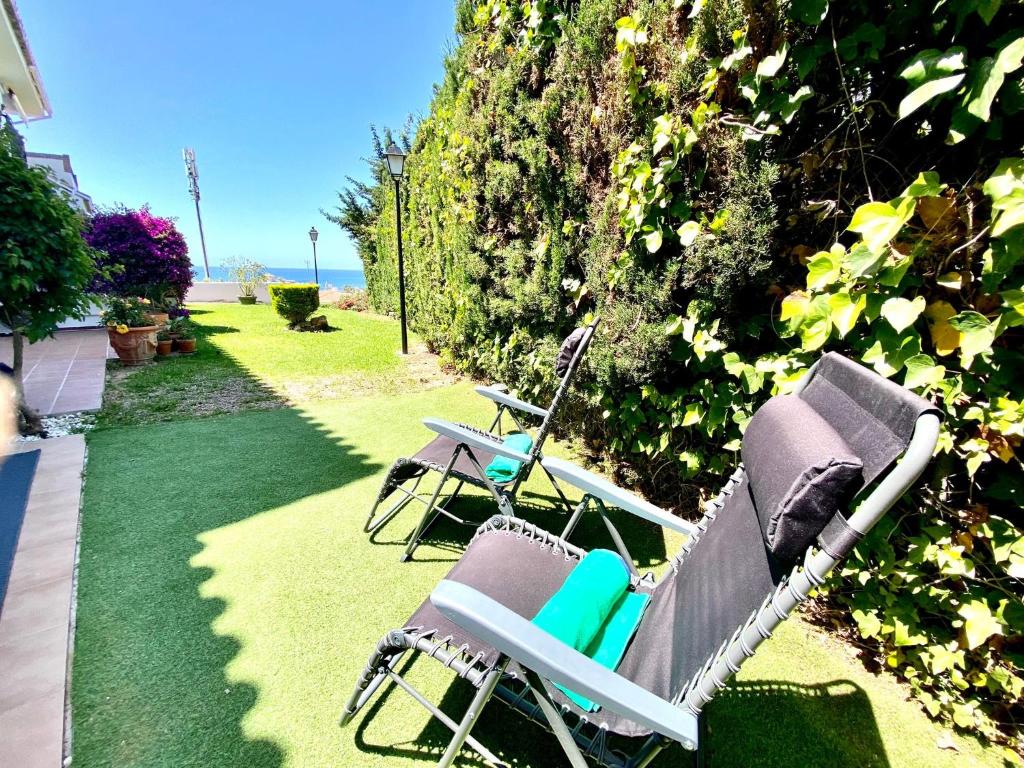 two chairs sitting on the grass in a yard at Wave & Garden Riviera - EaW Homes in Mijas Costa