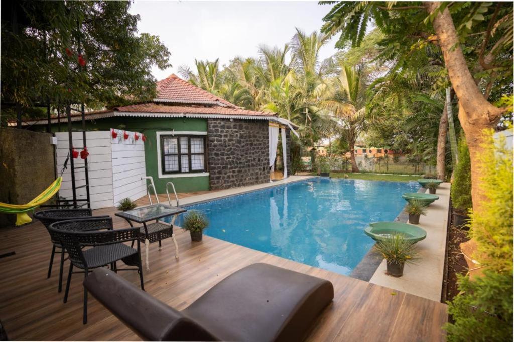 a swimming pool in a yard with a house at WayFare Stud Farm & Resort in Nashik