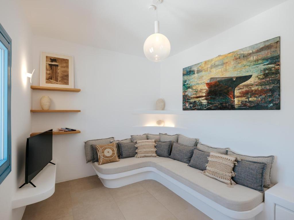 a living room with a white couch and a painting at Kamara House - 200m from Naoussa Port in Naousa