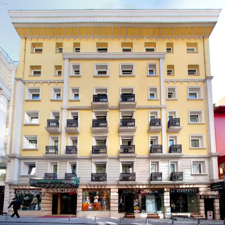 a yellow building with balconies on a street at Oran Hotel in Istanbul