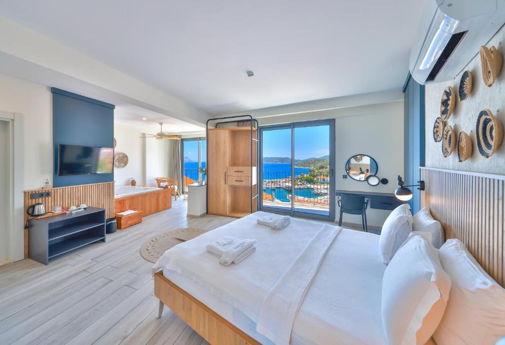 a bedroom with a large bed with a view of the ocean at Kas Athena Hotel in Kaş