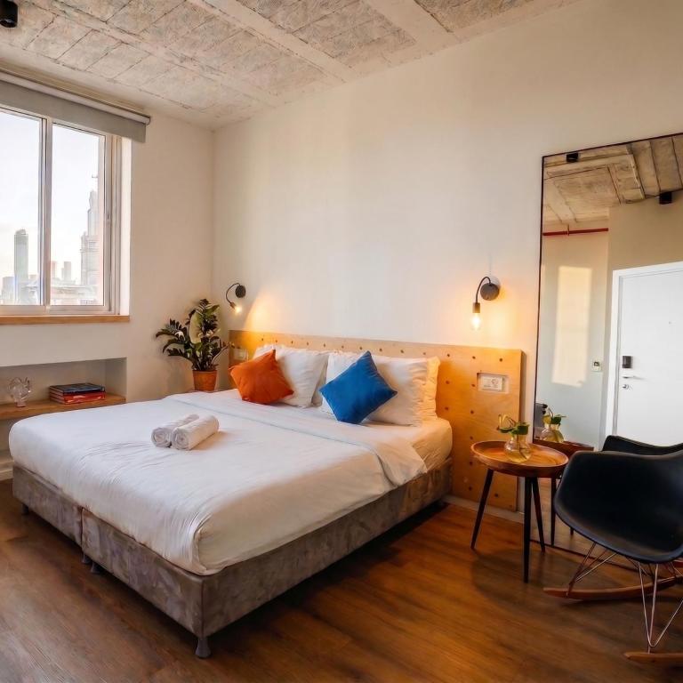 a bedroom with a bed and a table and a mirror at Domus Metro Hotel in Tel Aviv