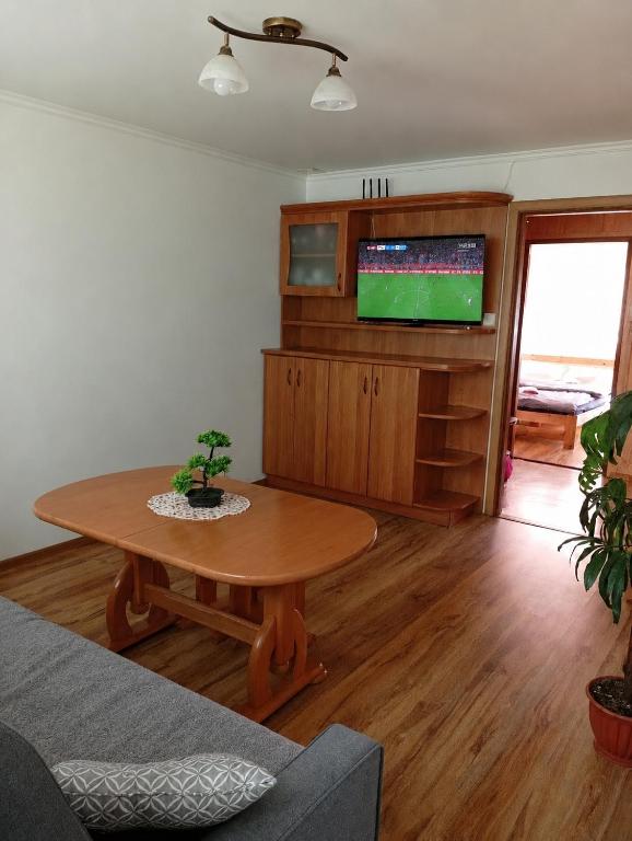 a living room with a table and a tv at Komfortowy Apartament na wyłączność 2 Sypialnie Blisko Centrum in Gorlice