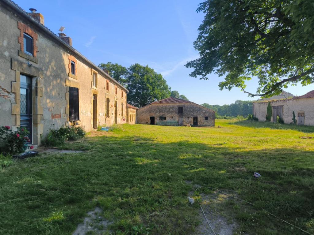 an old building with a grass field next to it at La demeure de vos désirs in Pressac