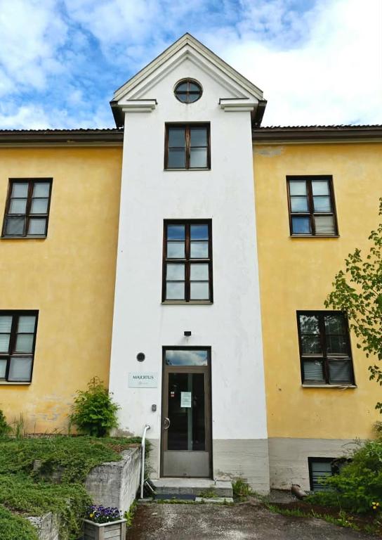a yellow and white building with a door at Majoitus Fox in Kuopio