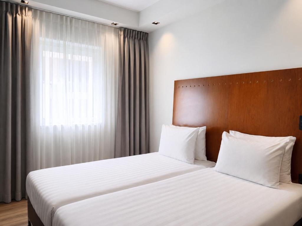 ein Hotelzimmer mit zwei Betten und einem Fenster in der Unterkunft SeaNet Hotel By AFI Hotels in Tel Aviv
