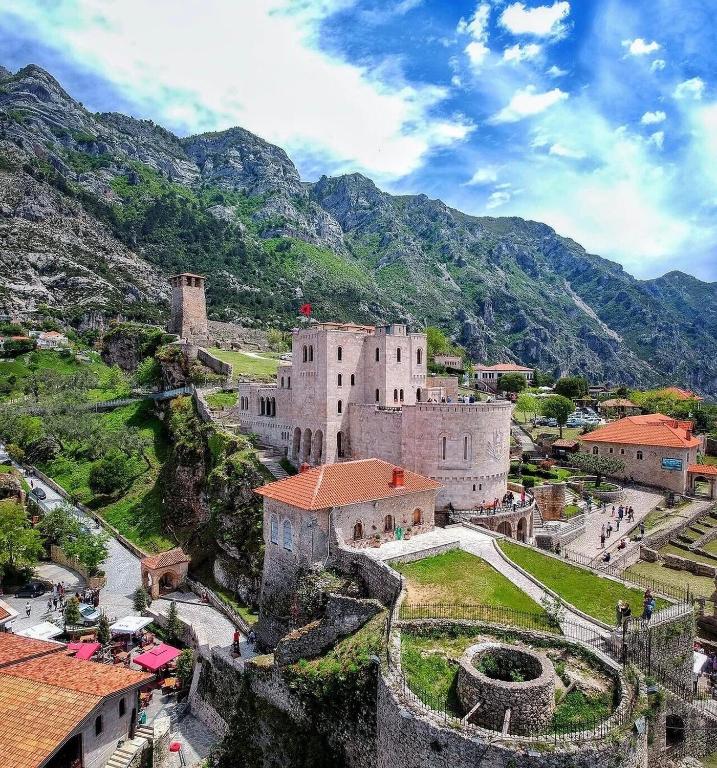an old building on a hill with mountains in the background at House Hasa in Krujë