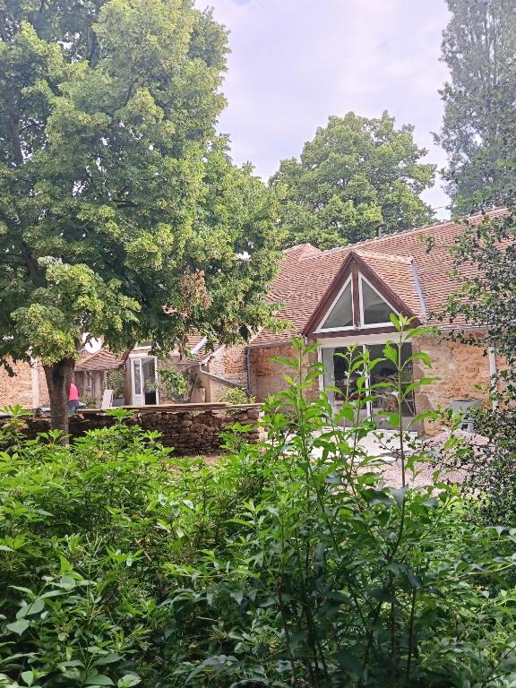 a brick house with trees in front of it at Domaine le bas bois in Neuville-sur-Sarthe