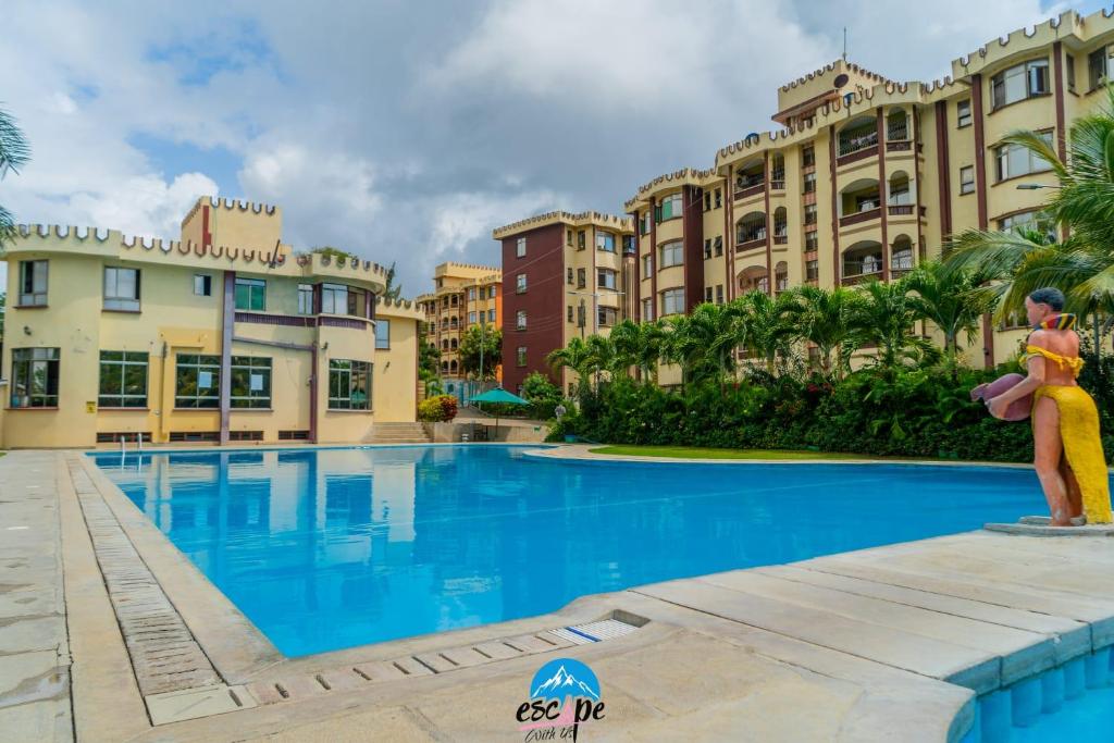 a pool at a resort with a person standing next to it at Amboseli 2 in Mombasa