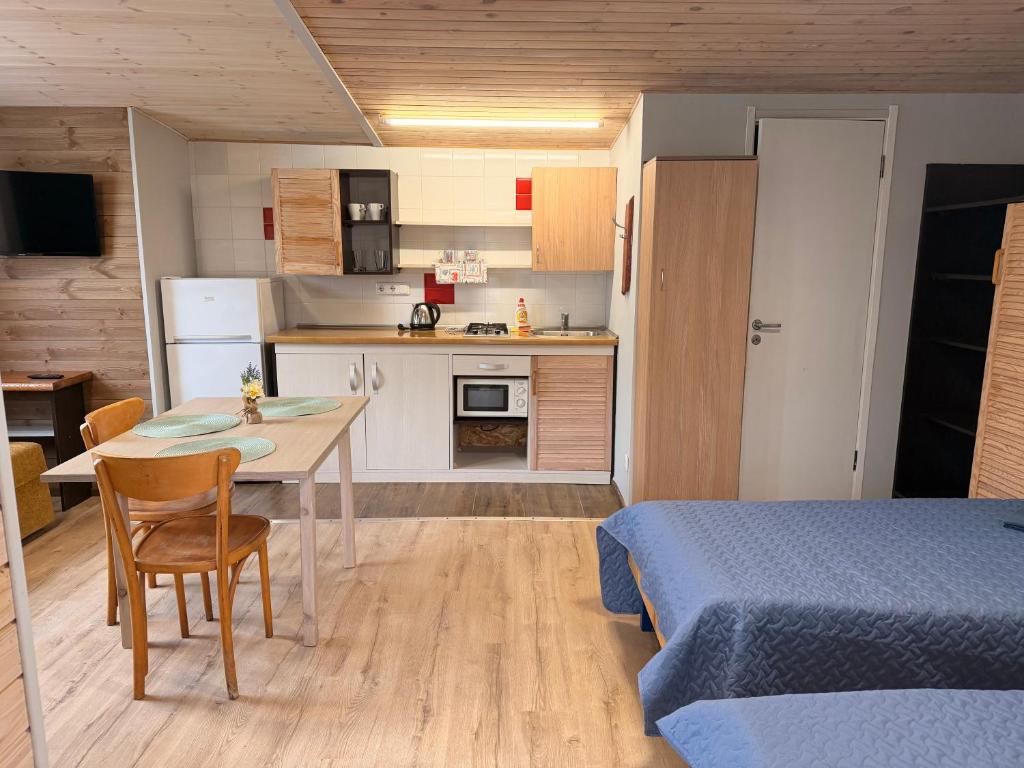 a room with a kitchen and a table and a bed at Pylimo slėnis in Palanga