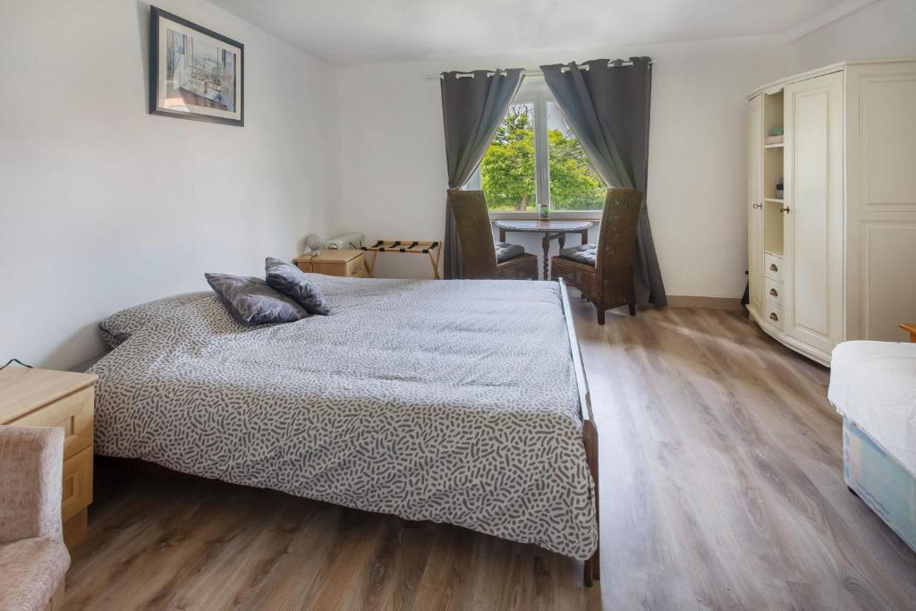a bedroom with a bed and a table and a window at Chambre d'hotes 3 et 4 a la ferme in Champsac