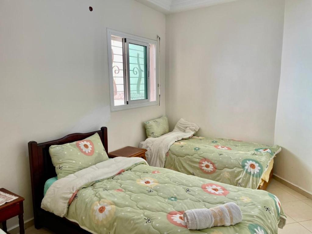 a bedroom with two beds and a window at luxury apartment in fez in Fez