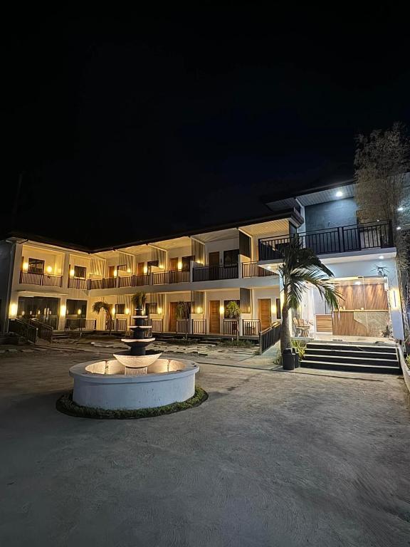 a building with a fountain in front of it at night at The Annwin Hotel - Sablayan in Sablayan