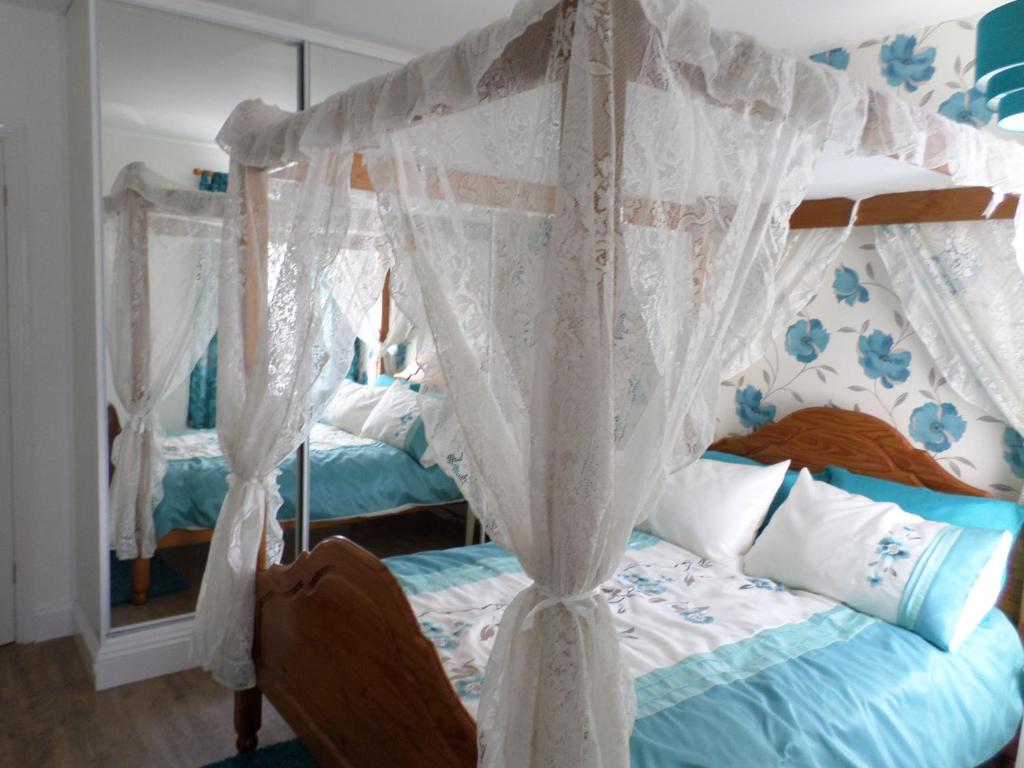 a bedroom with a bed with a canopy at Sunrise Cottage in Lowestoft