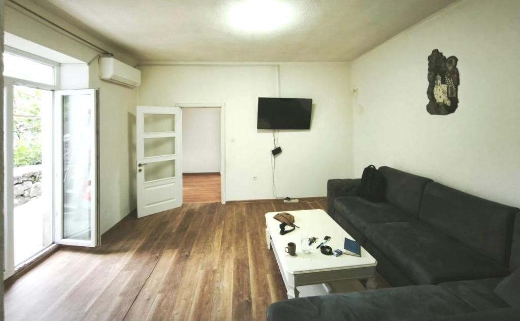 a living room with a couch and a table at Spacious City Center Apartment for 6 - Steps from Hilton & Republic Square in Podgorica