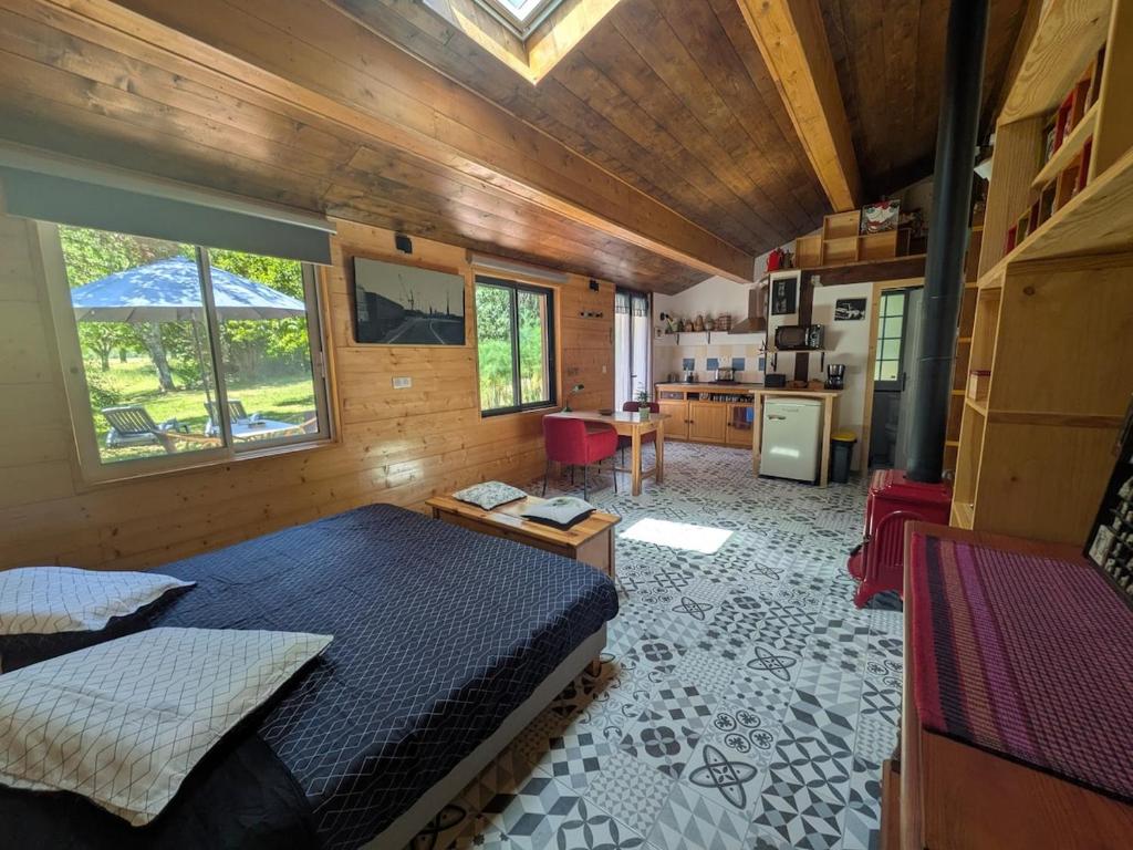 a bedroom with a large bed and a kitchen at LoFt Les Castilléres in Condat-sur-Trincou