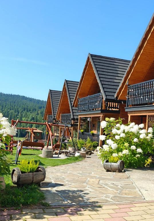a house with a playground in front of it at Domki u Jacka - Rodzinny Relaks w Górach, SPA i atrakcje dla dzieci in Ząb