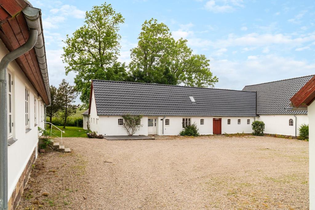 two white buildings with a driveway in front at The White Farm in Skanderborg