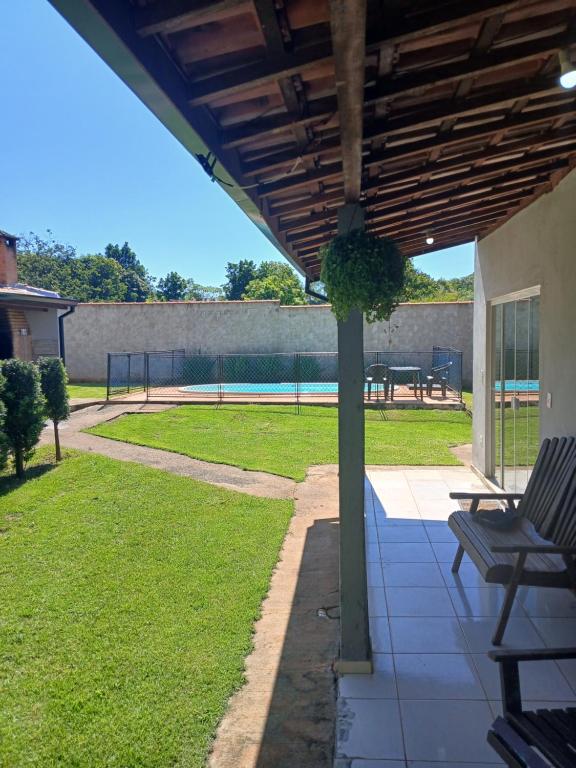 a patio with two chairs and a tennis court at Recanto Lyra in Indaiatuba