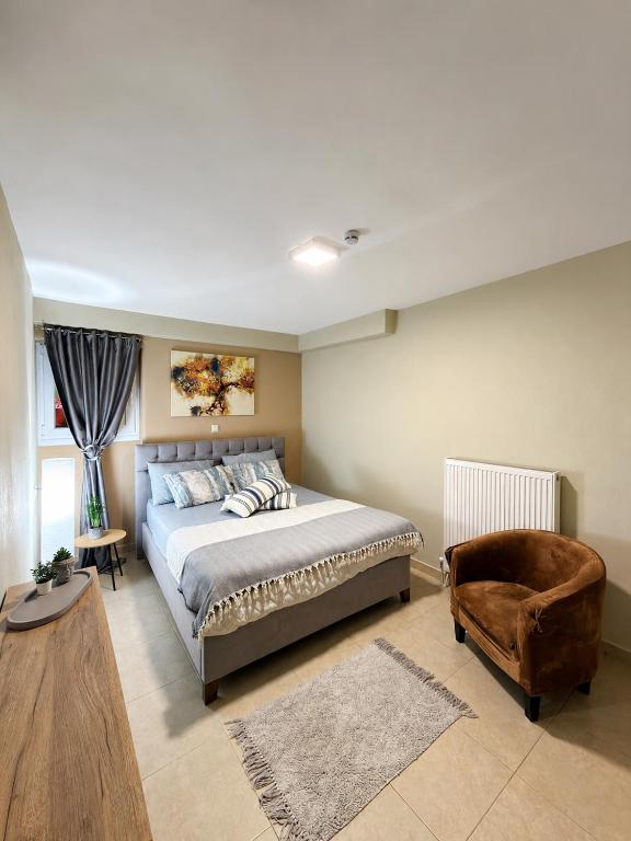 a bedroom with a large bed and a chair at Filemial House in Agios Mamas