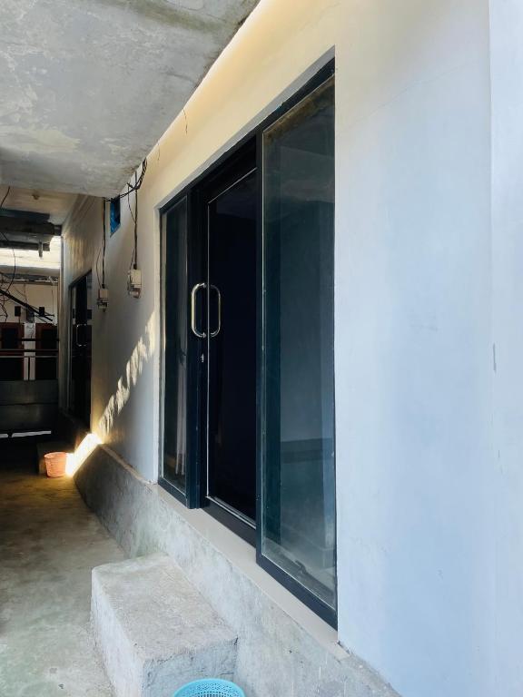 a building with large windows with a bench next to it at AFWA Surf and Stay in Selong Belanak
