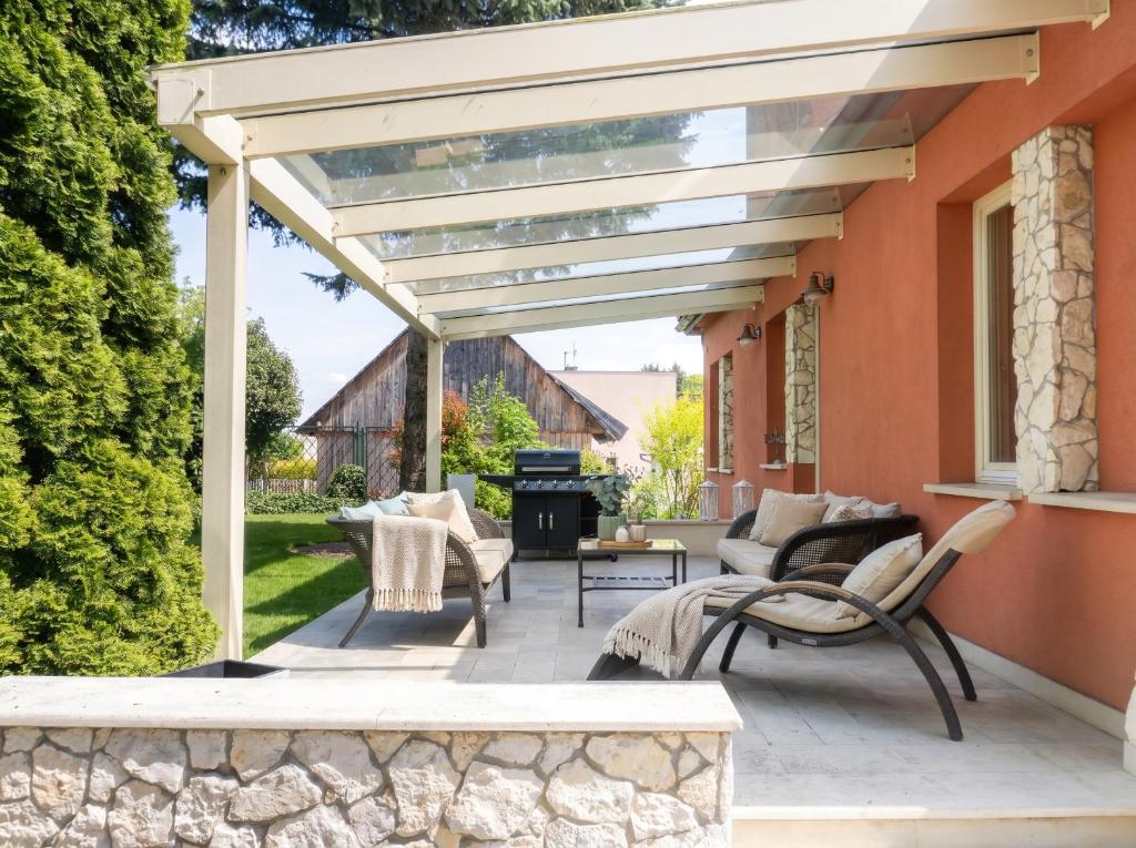 a patio with a white pergola and a grill at Golden Villas Luxury Garden Villa - Kraków in Węgrzce