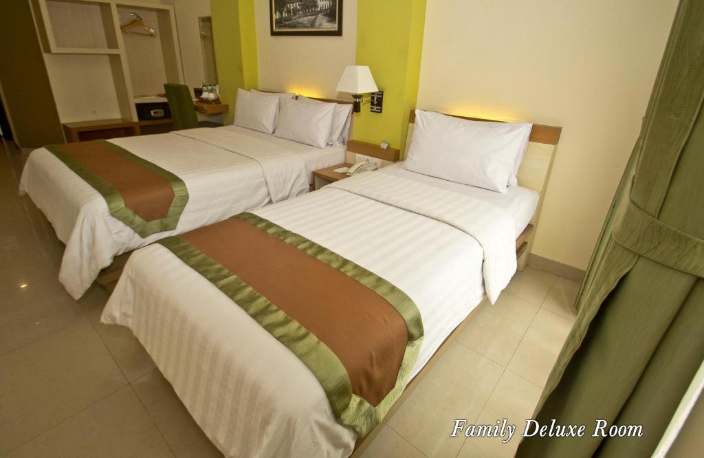 Postel nebo postele na pokoji v ubytování De Batara Hotel