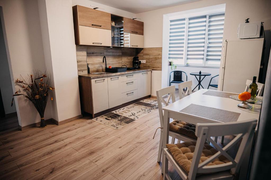 a kitchen with a table and a dining room at The Home in Gheorgheni