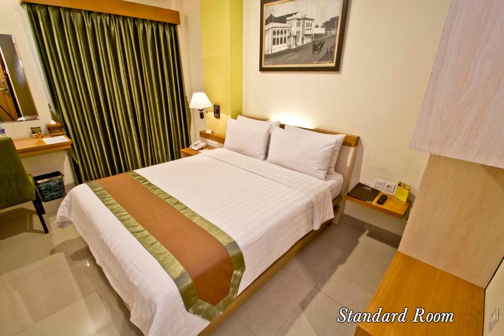 Postel nebo postele na pokoji v ubytování De Batara Hotel