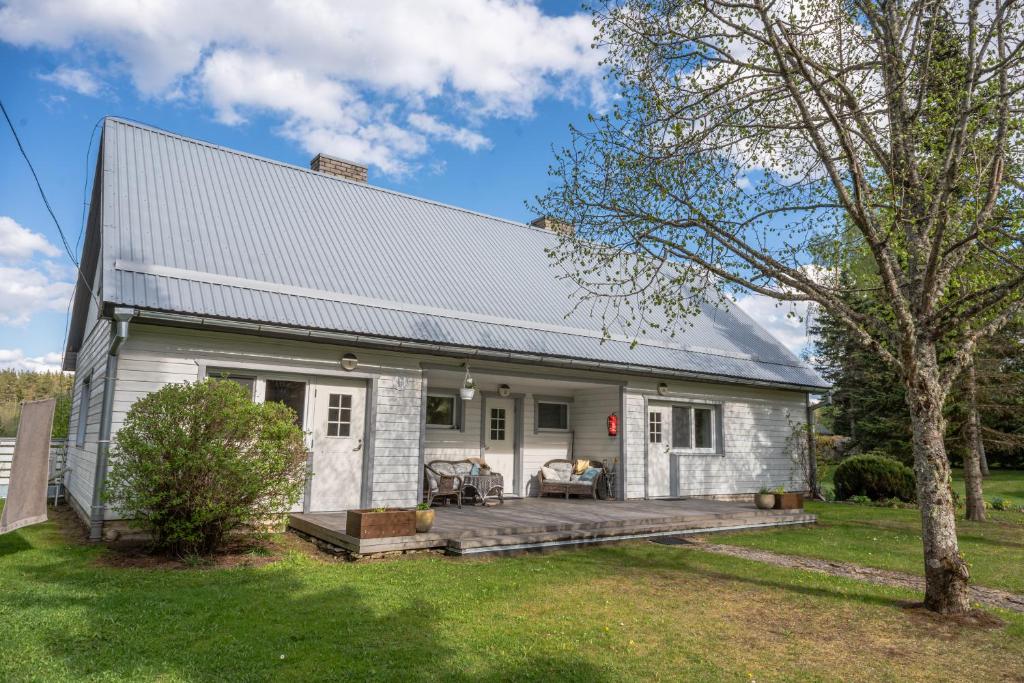 a white cottage with a porch and a yard at Ämmamoori Maja - Mother-in-Law's House in Palmse