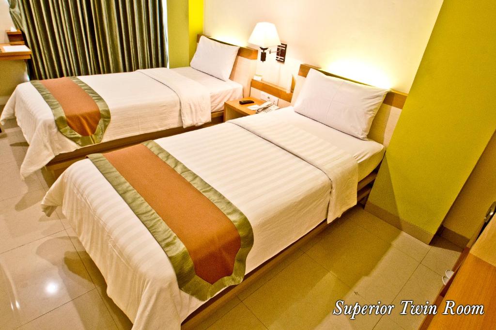 Postel nebo postele na pokoji v ubytování De Batara Hotel