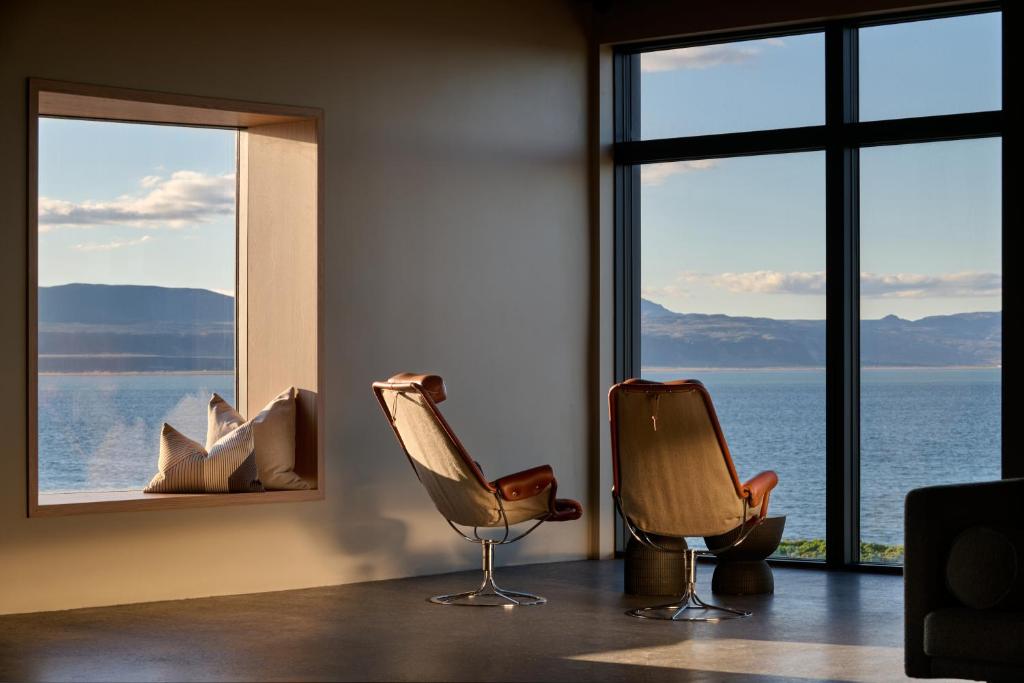two chairs in a room with a view of the ocean at Black Sand Hotel in Ölfus
