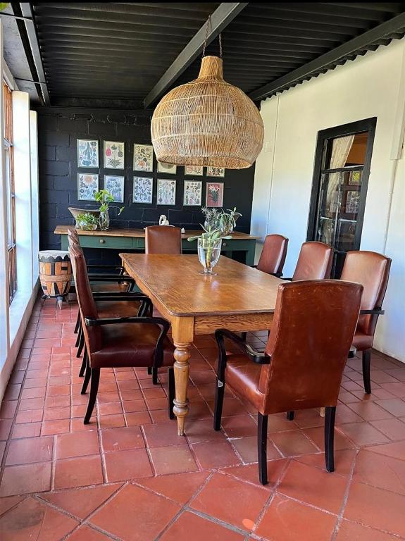 a dining room with a wooden table and chairs at De Oude Schuur in Stellenbosch
