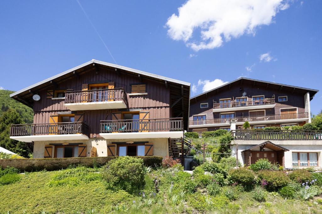 a large wooden house with balconies on a hill at L'Edelweiss - Bouvier in Aillon-le-Jeune