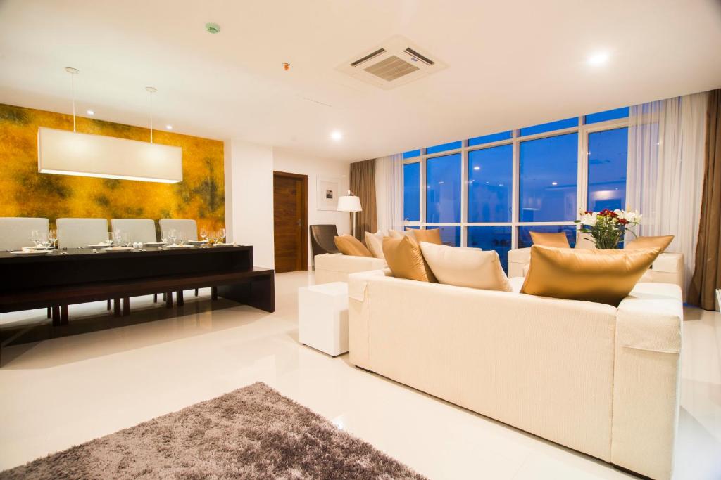 ein Wohnzimmer mit einem weißen Sofa und einem Tisch in der Unterkunft Platinum One Suites in Colombo