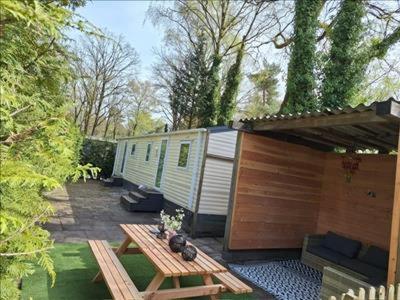 an rv with a picnic table and a picnic table sidx sidx at Leuke 6 persoons stacaravan op top locatie! in Hoenderloo