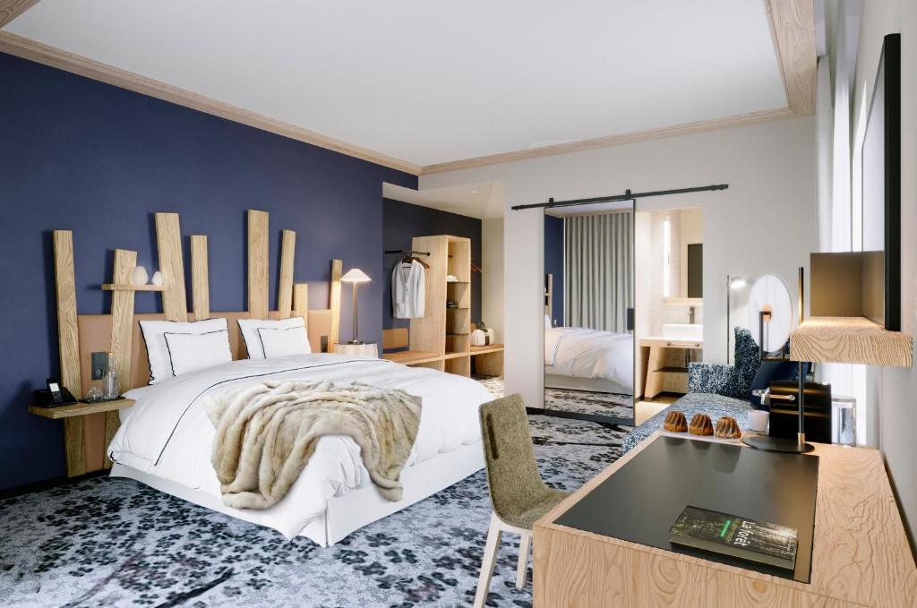 a bedroom with a large white bed and a blue wall at Domaine de l'éclaircie in Saint-Quirin