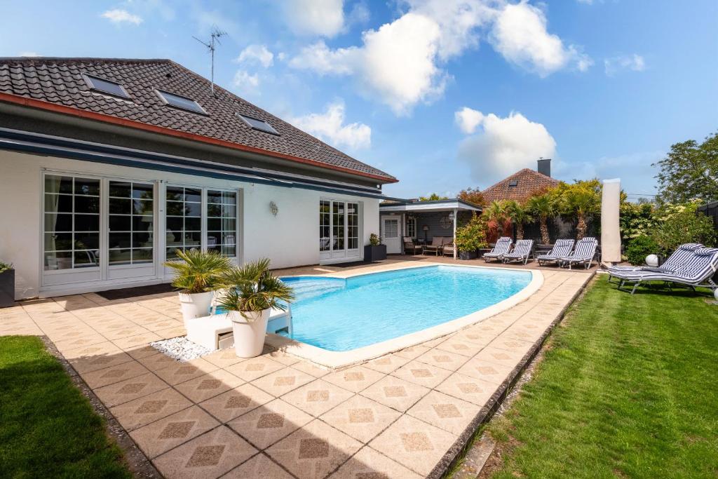 a swimming pool in the backyard of a house at Villa Béatrice - Piscine in Hochfelden