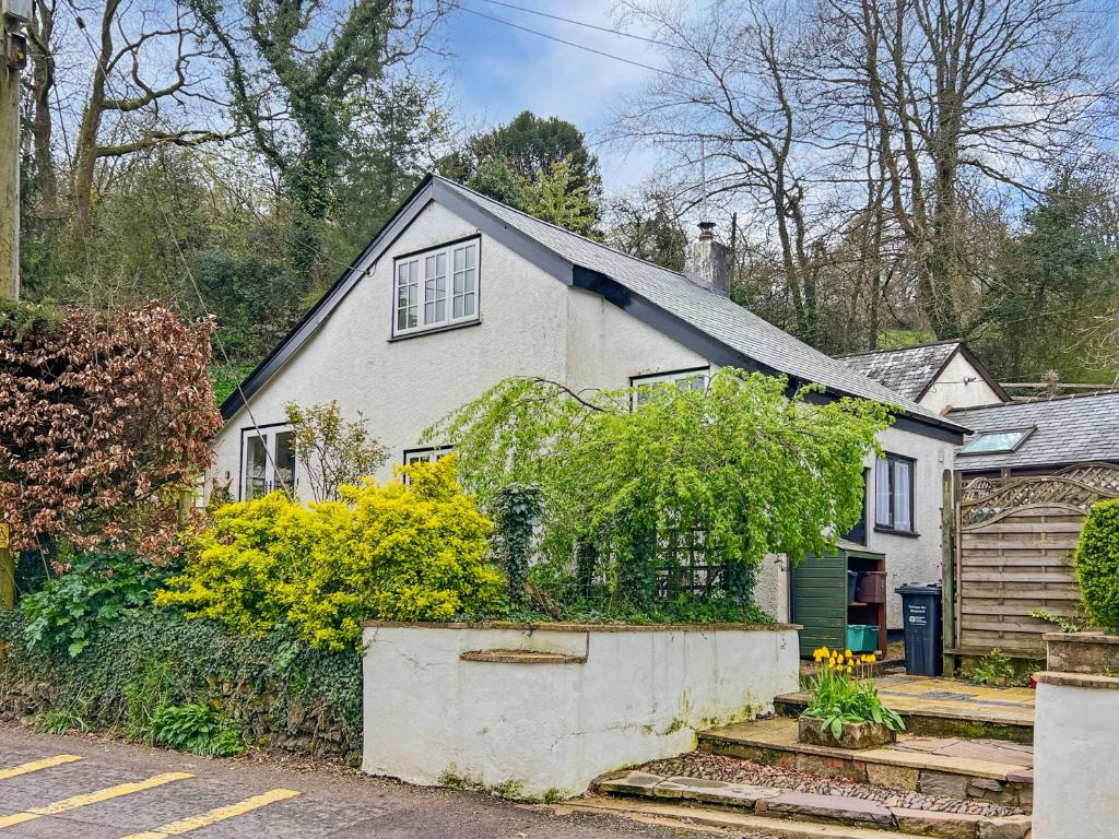 a white house with a garden in front of it at The Coach House Dulverton in Dulverton