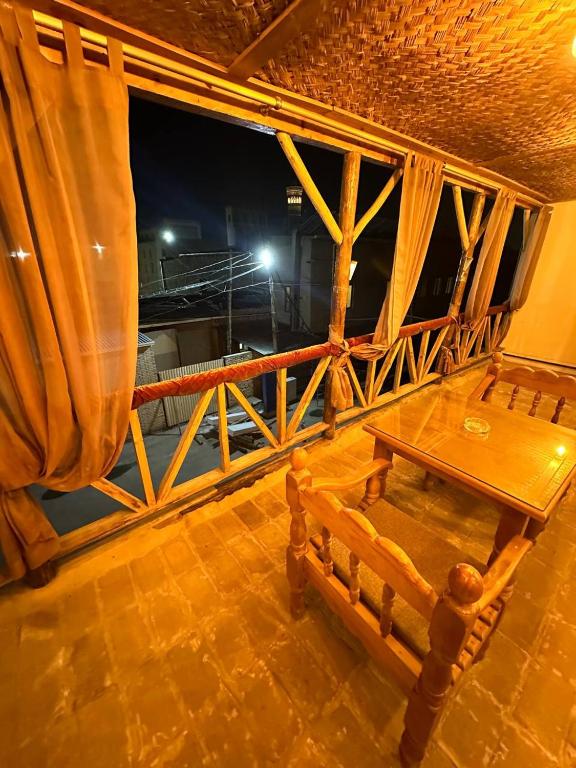 a table and bench on a balcony at night at Nabibek boutique in Bukhara