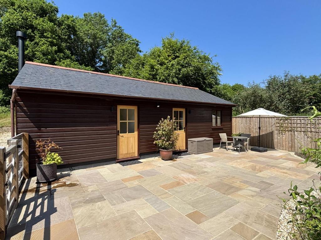 a small shed with a patio in front of it at Bramble Bank in Dorchester