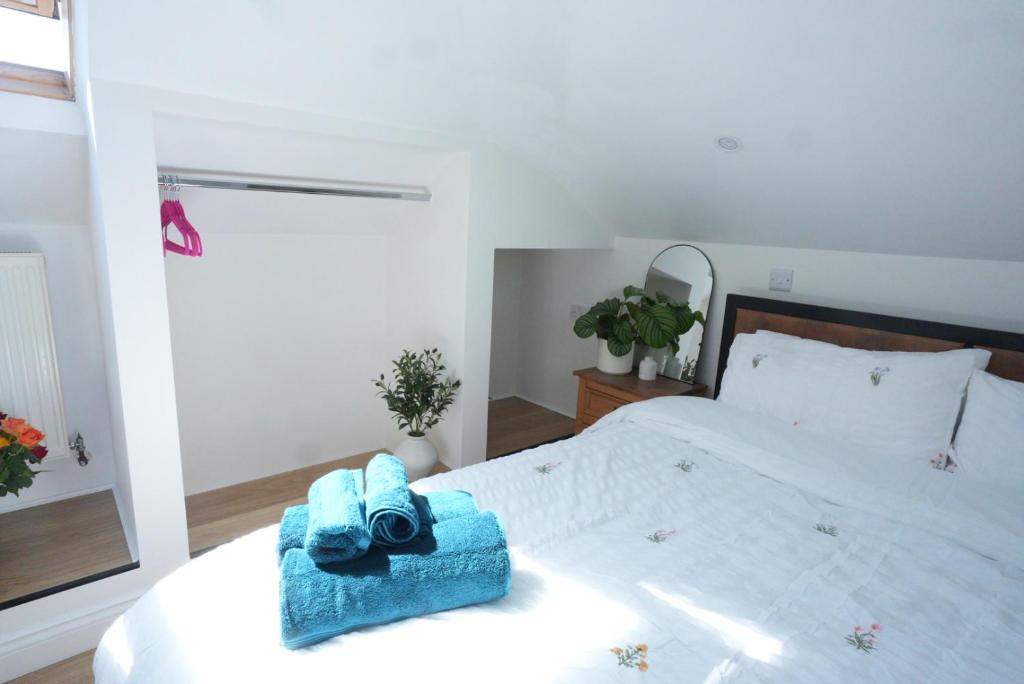 a bedroom with a bed with a blue towel on it at Steps to the Sand in Melcombe Regis