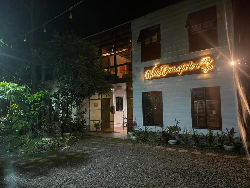 a sign on the side of a building at night at Villa Concepcion Staycation by ngb in Real
