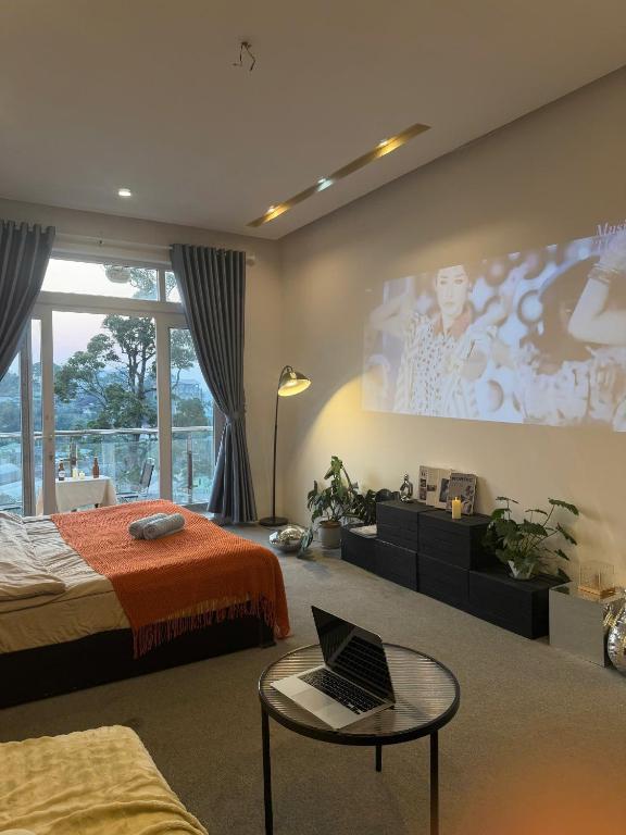a bedroom with a bed and a laptop on a table at MiMo Homestay Đà Lạt in Xuan An