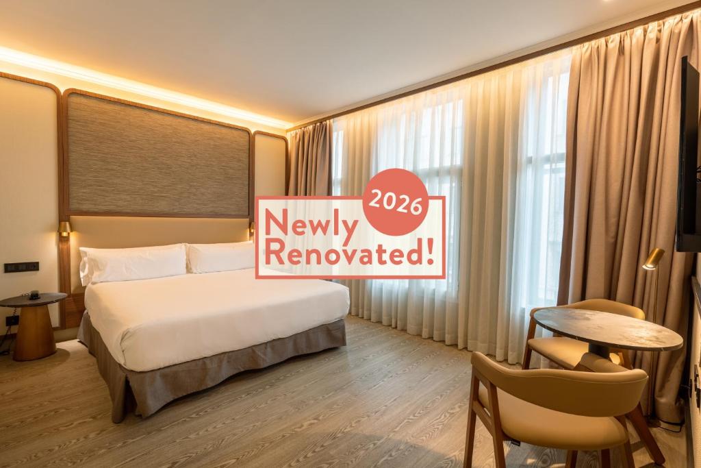a hotel room with a bed and a sign that says new renovated at Petit Palace Alcalá in Madrid